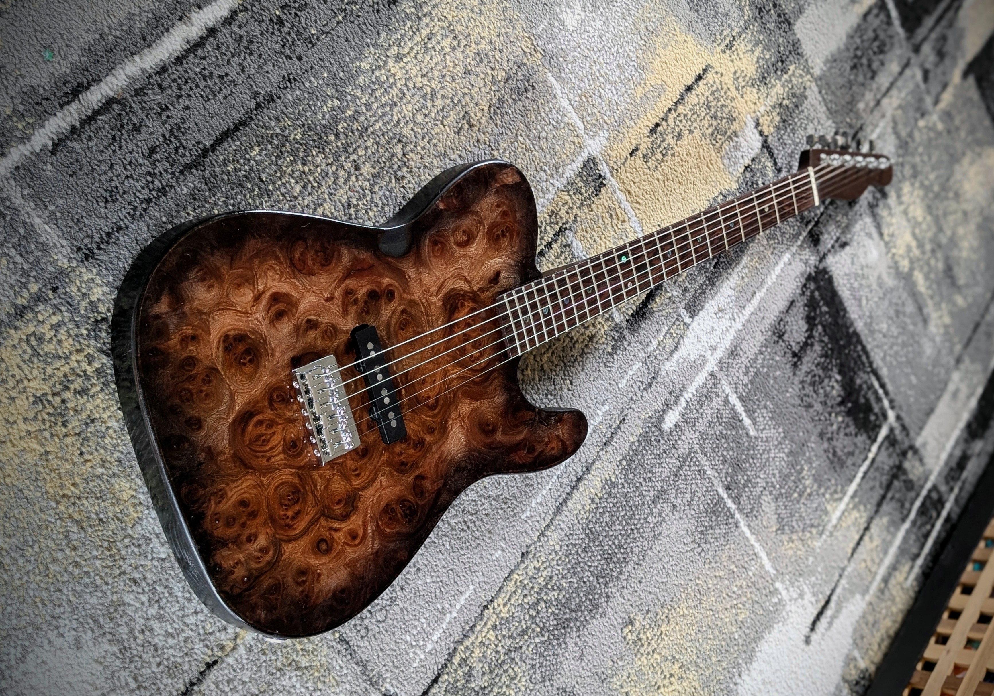 Custom built burl top telecaster with a bass pickup in a 6 string guitar